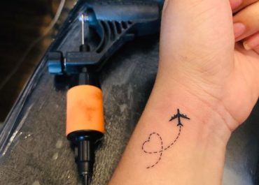 Tatuajes pequeños para mujer con símbolos de viaje en la muñeca