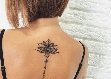 Tatuajes pequeños para mujer con loto en la espalda